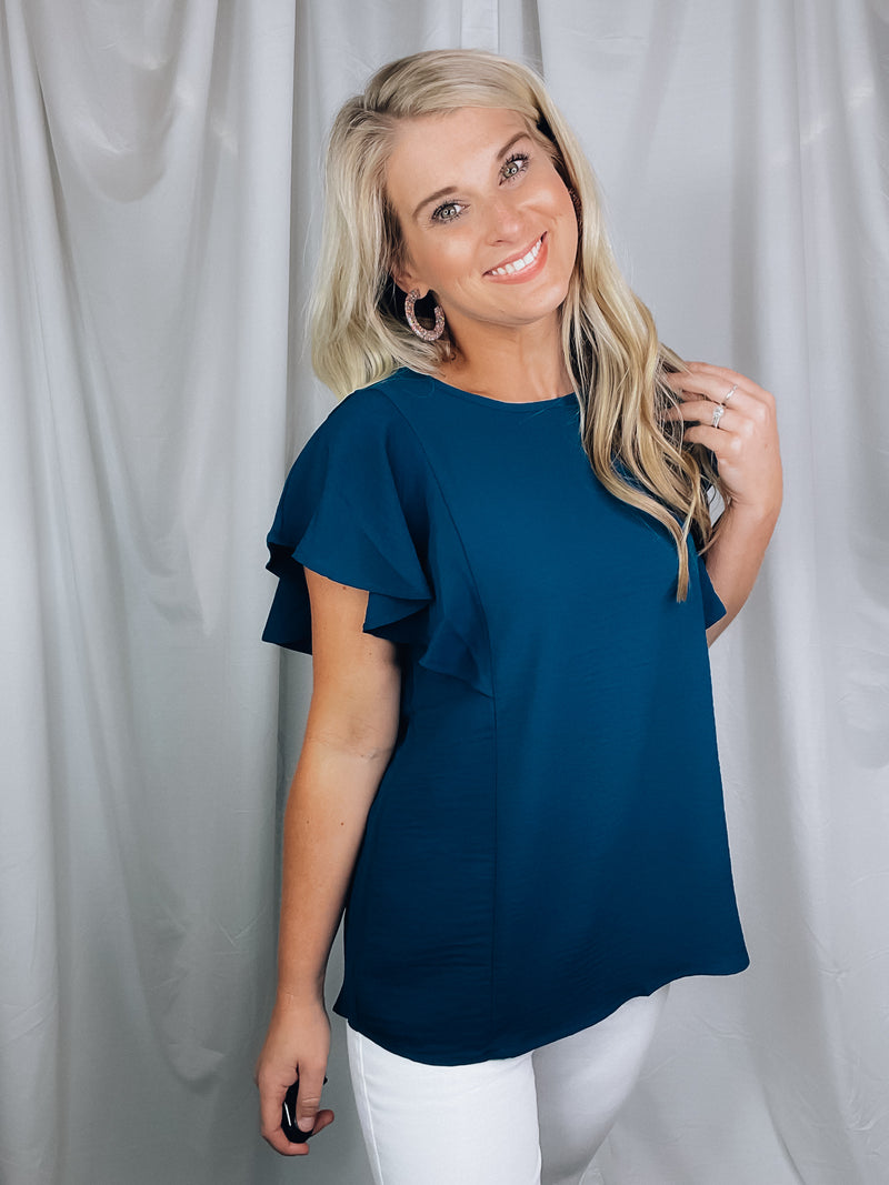 Top features a solid base color, stretchy material, short ruffle sleeves, round neck line and runs true to size!-navy