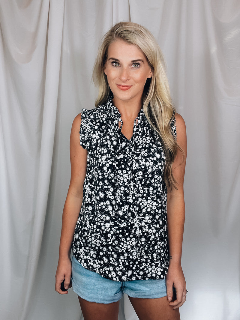 Top features a solid base color, floral print detail, sleeveless ruffle top, ruffle neck line and runs true to size!-black