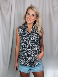 Top features a solid base color, floral print detail, sleeveless ruffle top, ruffle neck line and runs true to size!-black