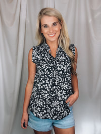 Top features a solid base color, floral print detail, sleeveless ruffle top, ruffle neck line and runs true to size!-black