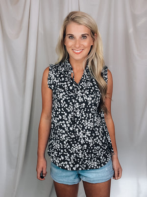 Top features a solid base color, floral print detail, sleeveless ruffle top, ruffle neck line and runs true to size!-black