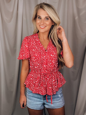 Top features a solid base color, white printed detail, short sleeves, V-neck line, synched waist, adjustable synched waist and runs true to size! 