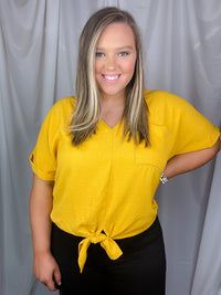 Top features a solid base color, V-neck line, cuffed short sleeves, front waist tie detail, loose fit and runs true to size!-mustard