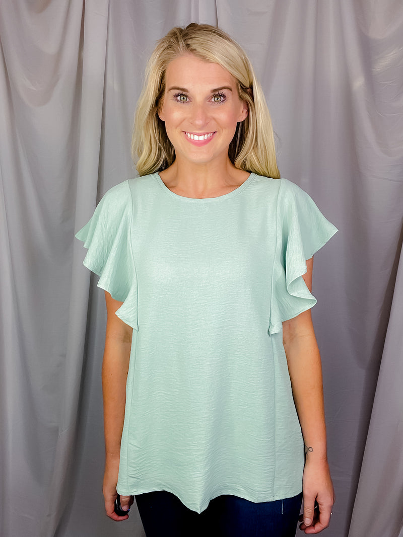 Top features a solid base color, stretchy material, short ruffle sleeves, round neck line and runs true to size!-mint