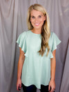 Top features a solid base color, stretchy material, short ruffle sleeves, round neck line and runs true to size!-mint