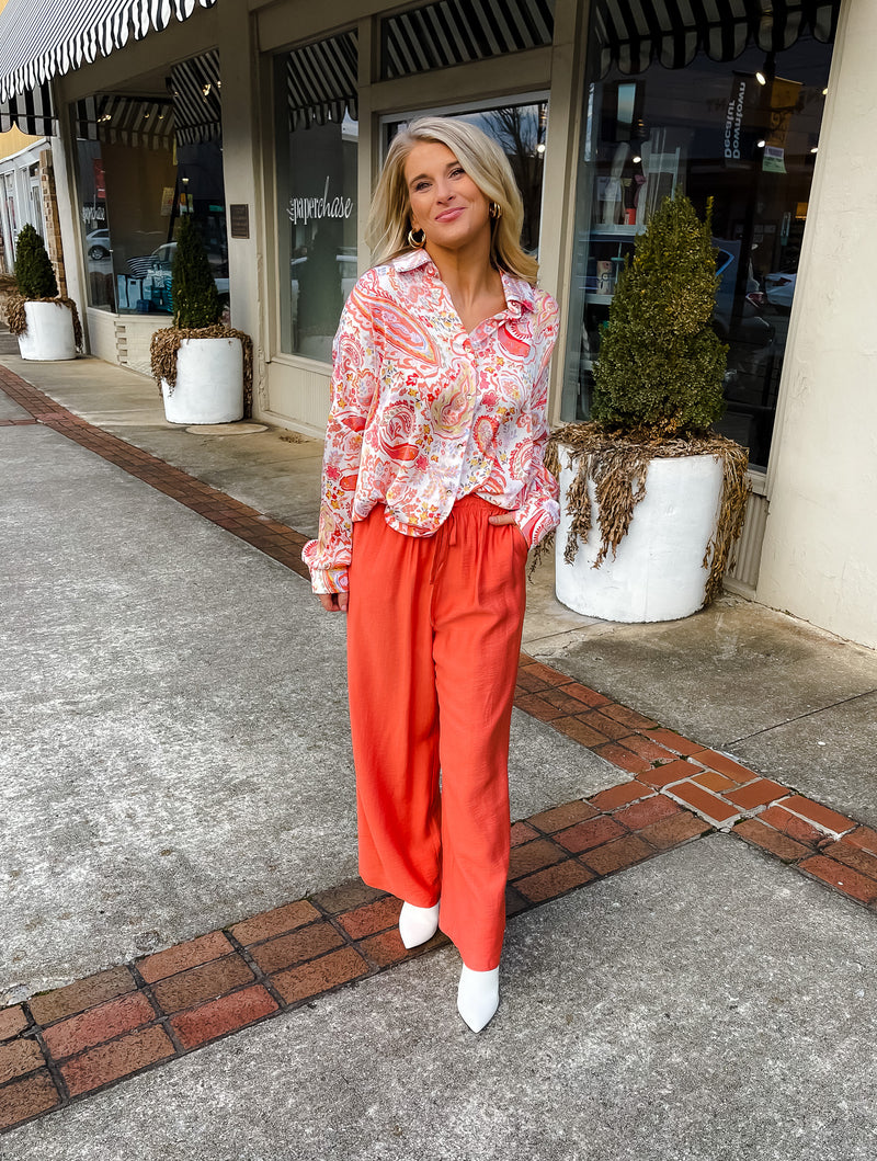 This paisley print top bring our your inner retro side. Top features a fun pink/orange coloring, oversized fit, long cuff sleeves, collar detail, functional button down closure and runs very oversized.