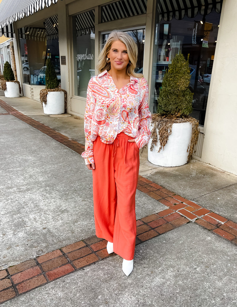 This paisley print top bring our your inner retro side. Top features a fun pink/orange coloring, oversized fit, long cuff sleeves, collar detail, functional button down closure and runs very oversized.