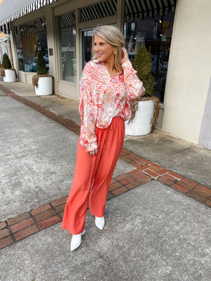 This paisley print top bring our your inner retro side. Top features a fun pink/orange coloring, oversized fit, long cuff sleeves, collar detail, functional button down closure and runs very oversized.