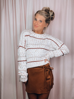 Top features an ivory base, multi colored popcorn and striped detailing, long sleeves, and runs true to size! -rust