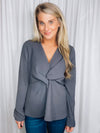 Top features a charcoal base, long sleeves, V-neck line, peplum fit, front knot detail, and runs true to size! 