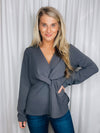 Top features a charcoal base, long sleeves, V-neck line, peplum fit, front knot detail, and runs true to size! 