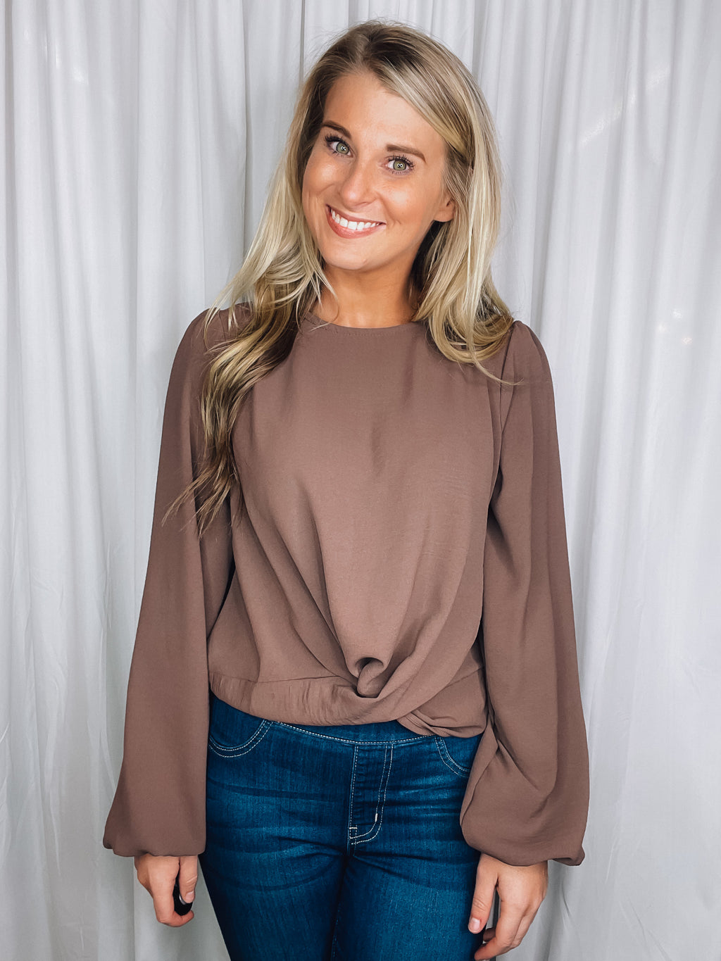 Top features a chocolate colored base, long sleeves, round neck line, cross twist detail and runs true to size! 