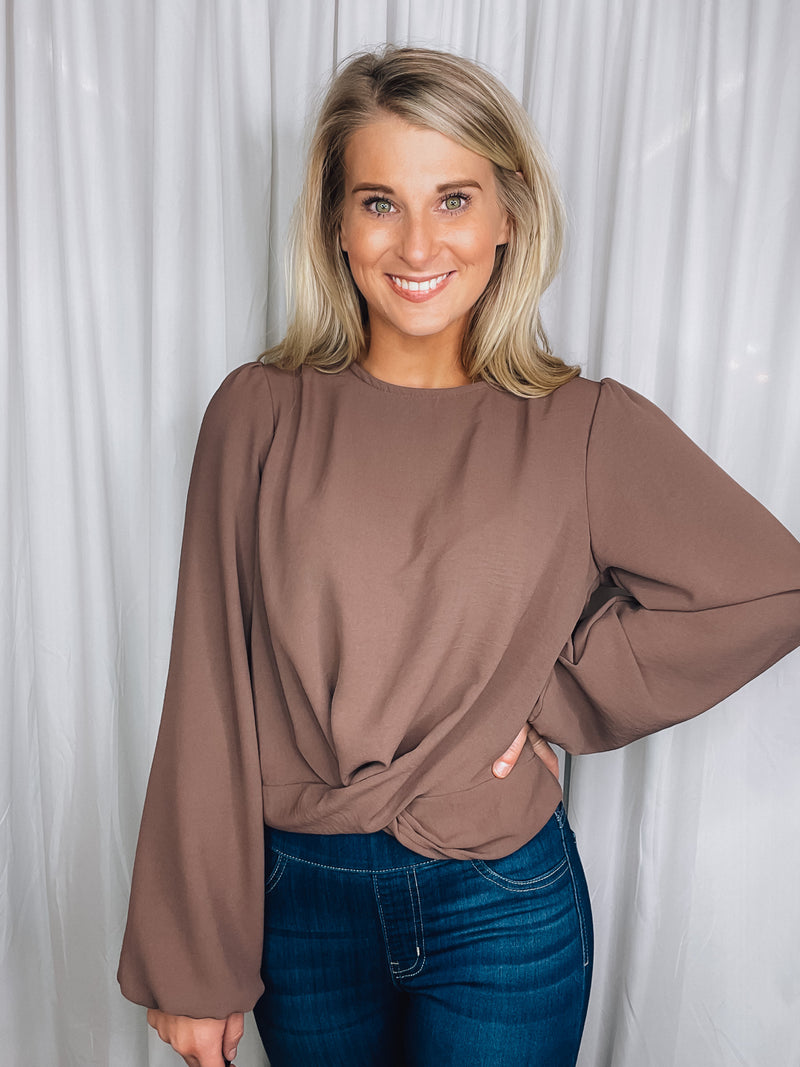 Top features a chocolate colored base, long sleeves, round neck line, cross twist detail and runs true to size! 