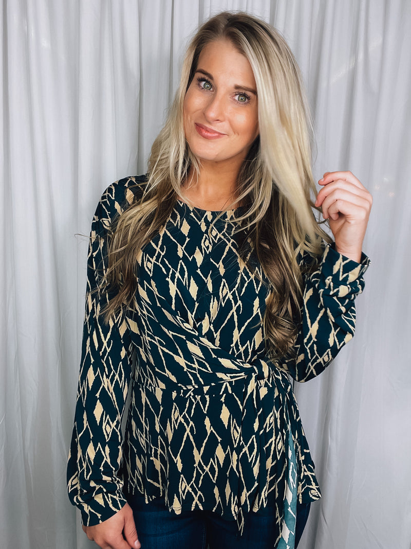 Top features a hunter green base, cream abstract print, long sleeves, V-neck line, tie front detail and runs true to size! 