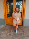 Romper features a neutral taupe color, short sleeves, waist strap detail, button black closure and runs true to size! 