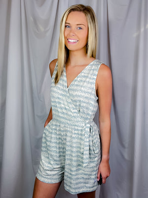Romper features a cream-teal color, faux wrap detail to add nice detailing, functional pockets, V-neck line, sleeveless detail and runs true to size! 