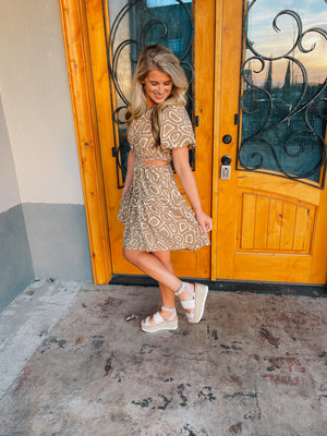 This mini dress is perfect for a sunny outing. Its tan hue, short sleeves, and side cutouts elegantly balance the abstract print, making it an ideal choice for those looking to look stylish and stay cool. Vacay ready, this piece is sure to be a crowd pleaser.