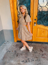 This mini dress is perfect for a sunny outing. Its tan hue, short sleeves, and side cutouts elegantly balance the abstract print, making it an ideal choice for those looking to look stylish and stay cool. Vacay ready, this piece is sure to be a crowd pleaser.