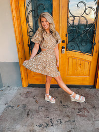 This mini dress is perfect for a sunny outing. Its tan hue, short sleeves, and side cutouts elegantly balance the abstract print, making it an ideal choice for those looking to look stylish and stay cool. Vacay ready, this piece is sure to be a crowd pleaser.