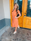 Dress features a sweet peach color, short sleeves, front twist detail, round  neck line, fitted fit and runs true to size! 