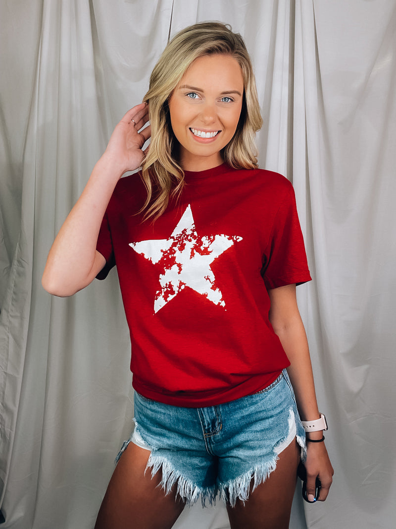 Graphic features a solid base color, distressed star print, short sleeves, round neck line, unisex fit and runs true to size! 