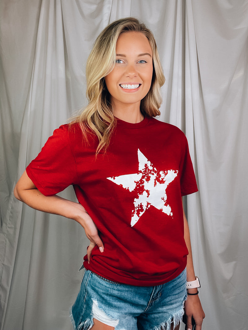 Graphic features a solid base color, distressed star print, short sleeves, round neck line, unisex fit and runs true to size! 