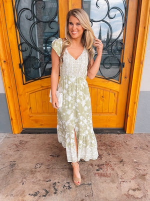 The Claim To Fame Midi dress is crafted from a light olive base that is adorned with an eye-catching white floral print. The midi dress features a flattering V-neck line, with short sleeves to complete the classic silhouette. Perfect for casual everyday wear or special occasions, this dress is sure to make a statement.