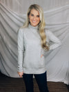 Sweater features a heather grey color, long sleeves, basic turtle neck ,long sleeves, cuff buttons and runs true to size! 