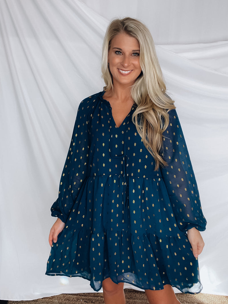 Dress features a solid base color, tiered look, long sleeves, gold detailing, button closure detail, lined detailing and runs true to size!-NAVY