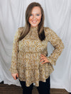 Top features a mustard base, long sleeves, white and black spotted detail, ruffle detail, round neck line, button closure and runs true to size! 