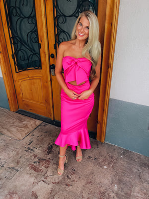 Dress features a solid base color, strapless detail, high-low hem line, front tie bow, mermaid fit and runs true to size! -hot pink