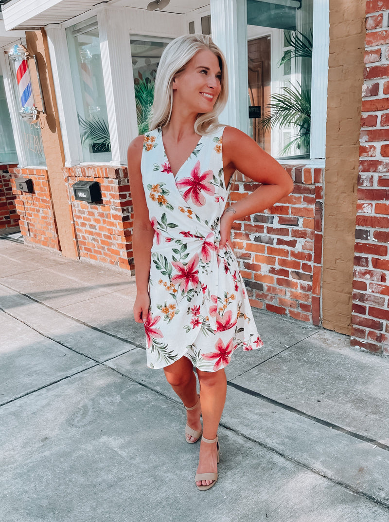 Dress features a simple ivory base, multi colored floral print, sleeveless detail, classic V-neck line, front tie wrap detail and runs true to size! 