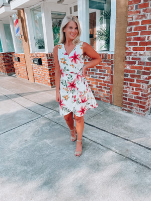 Dress features a simple ivory base, multi colored floral print, sleeveless detail, classic V-neck line, front tie wrap detail and runs true to size! 