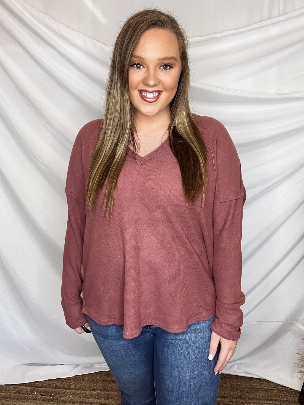 Top features a marsala colored base, long sleeves, light weight material, V-neck line and runs true to size! 