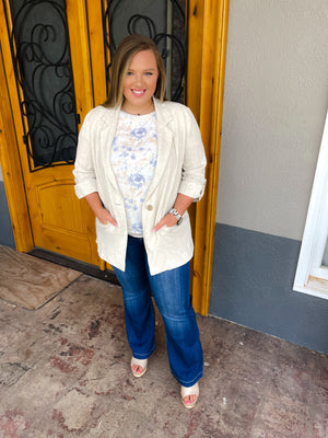 Top features a light ivory base, pale blue/ beige floral print, ruffle short sleeves, round neck line, underlining detail, back button closure and runs true to size! 
