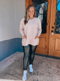 Top features a solid base color, long sleeves, front pocket detail, round neck line, cozy material and runs true to size! -taupe