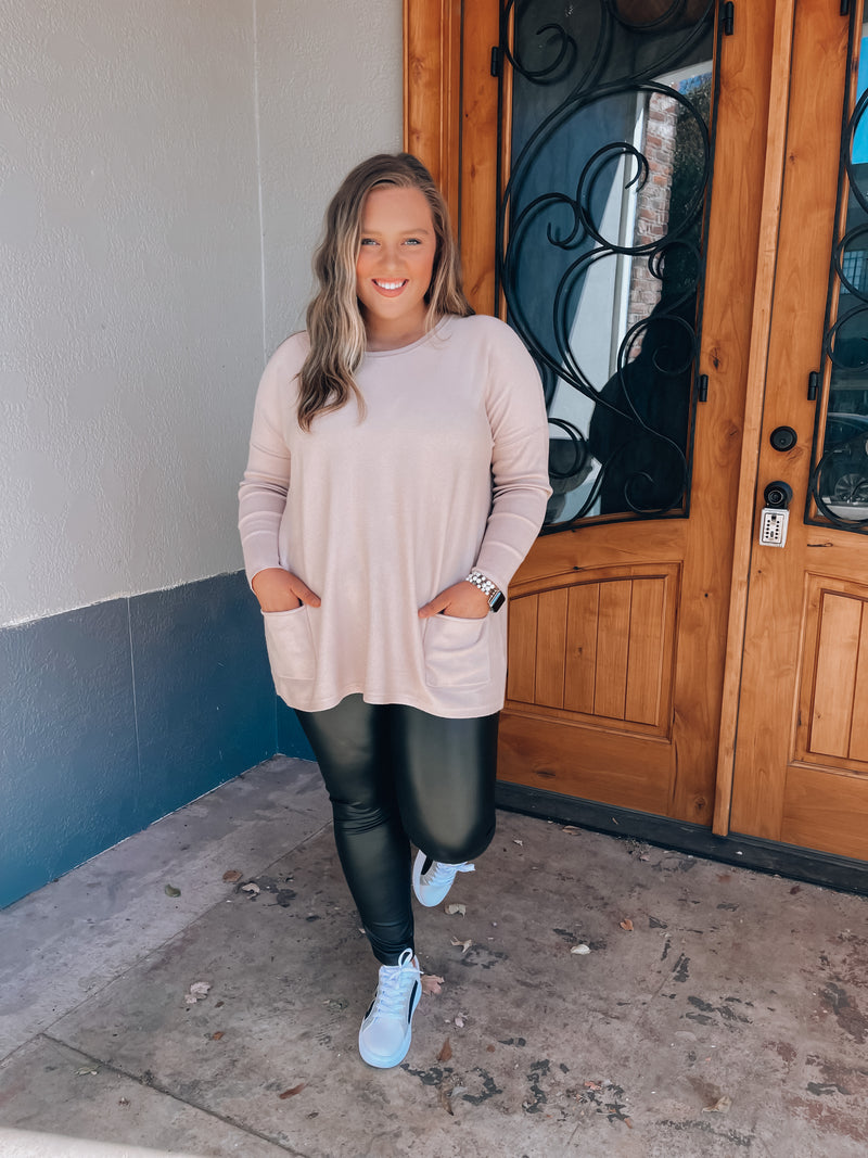 Top features a solid base color, long sleeves, front pocket detail, round neck line, cozy material and runs true to size! -taupe