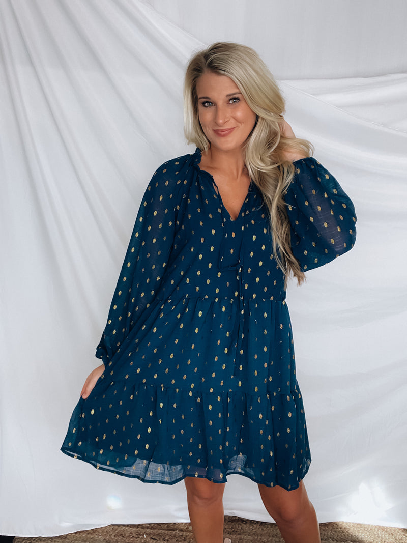 Dress features a solid base color, tiered look, long sleeves, gold detailing, button closure detail, lined detailing and runs true to size!-NAVY