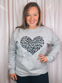 Graphic features a grey colored tee, black leopard heart design, long sleeves, round neck line, unisex fit and runs true to size! 