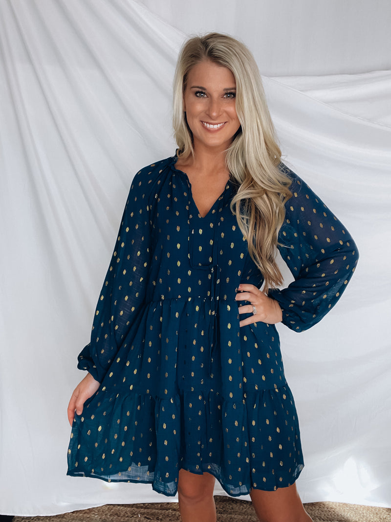 Dress features a solid base color, tiered look, long sleeves, gold detailing, button closure detail, lined detailing and runs true to size!-NAVY