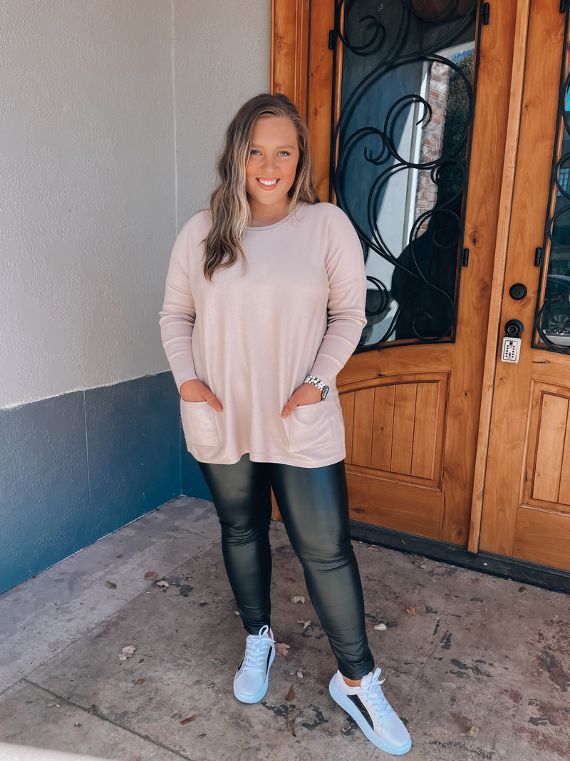 Top features a solid base color, long sleeves, front pocket detail, round neck line, cozy material and runs true to size! -taupe