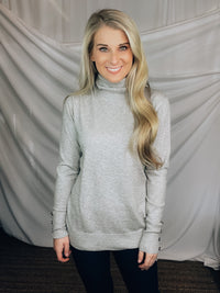 Sweater features a heather grey color, long sleeves, basic turtle neck ,long sleeves, cuff buttons and runs true to size! 