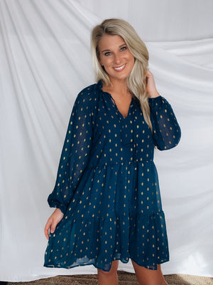 Dress features a solid base color, tiered look, long sleeves, gold detailing, button closure detail, lined detailing and runs true to size!-NAVY
