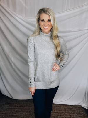 Sweater features a heather grey color, long sleeves, basic turtle neck ,long sleeves, cuff buttons and runs true to size! 