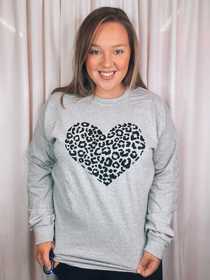 Graphic features a grey colored tee, black leopard heart design, long sleeves, round neck line, unisex fit and runs true to size! 