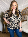 Top features a black colored base, taupe brush stroke print, short cuffed sleeves, V-neck detail and runs true to size!