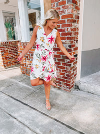 Dress features a simple ivory base, multi colored floral print, sleeveless detail, classic V-neck line, front tie wrap detail and runs true to size! 