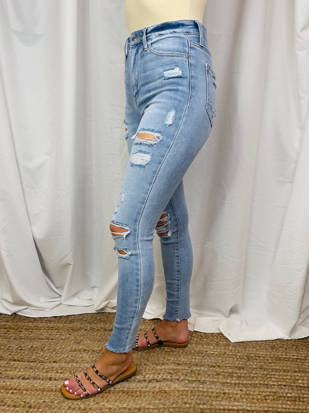 Jeans feature a light denim wash, high rise waist, functional pockets, front distressing detail, frayed ankle, skinny leg fit and runs true to size! 