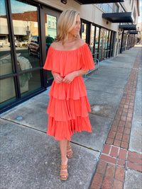 Dress features a coral color, layered detailing, off/on shoulder detail, underlining, midi length and runs true to size! 